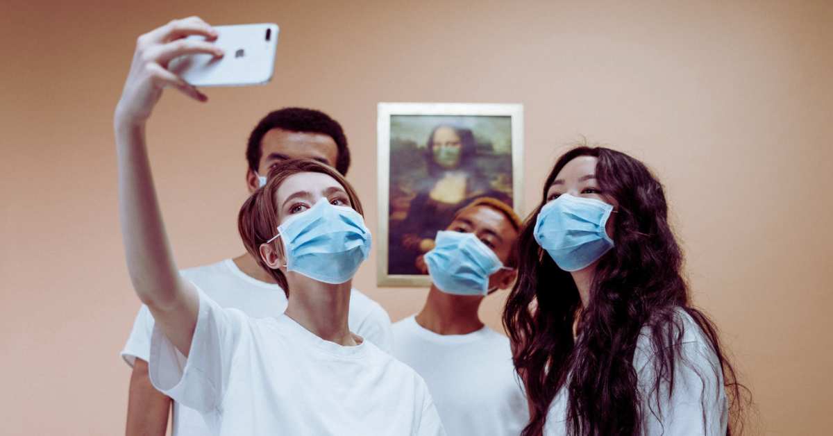 Social MEdia im Einsatz in der Zahnarztpraxis: junge Menschen machen Selfie mit Mundschutz