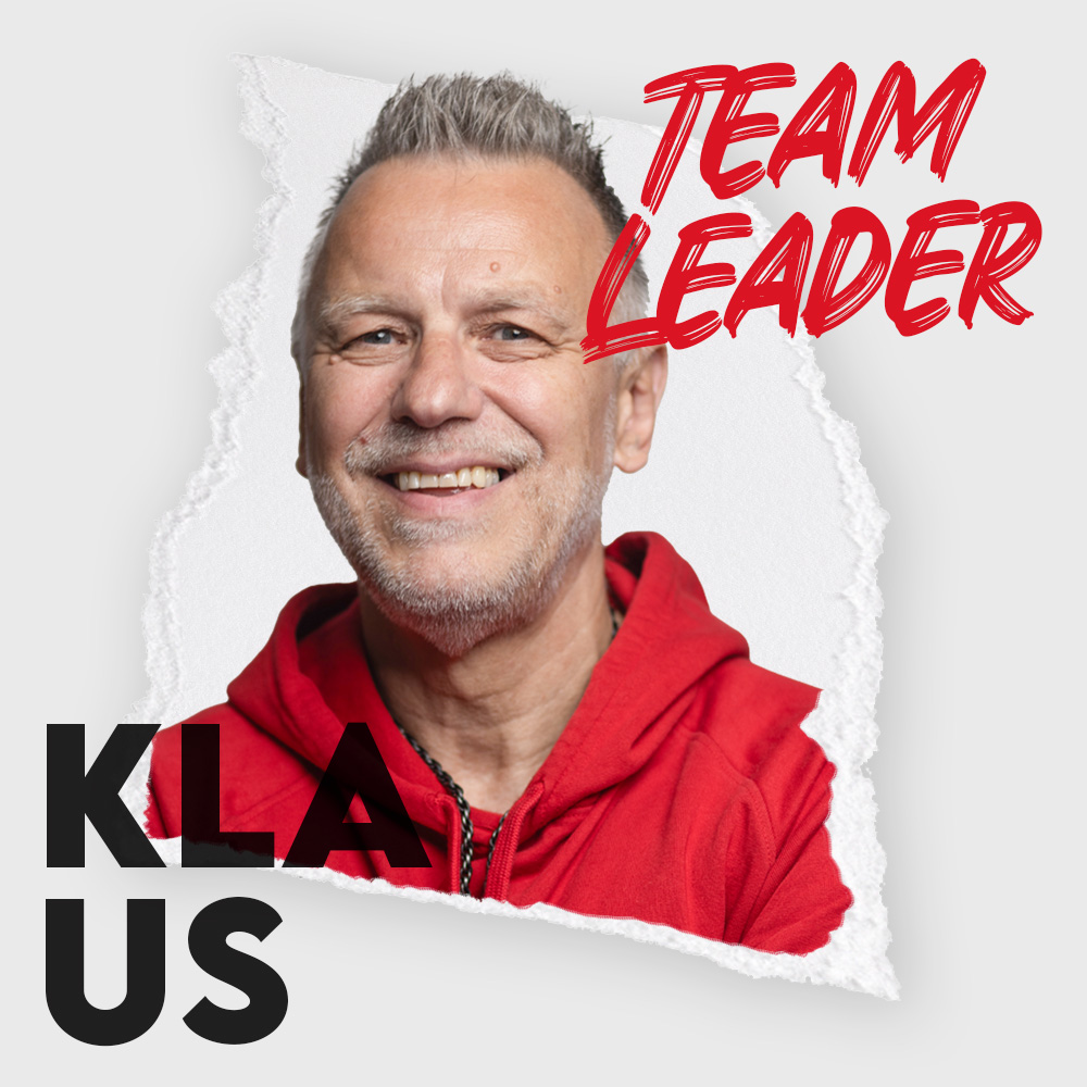 Grinsender Mann im roten Hoodie mit Team-Lead-Logo „TEAM LEADER“ und Namenszug „KLAUS“