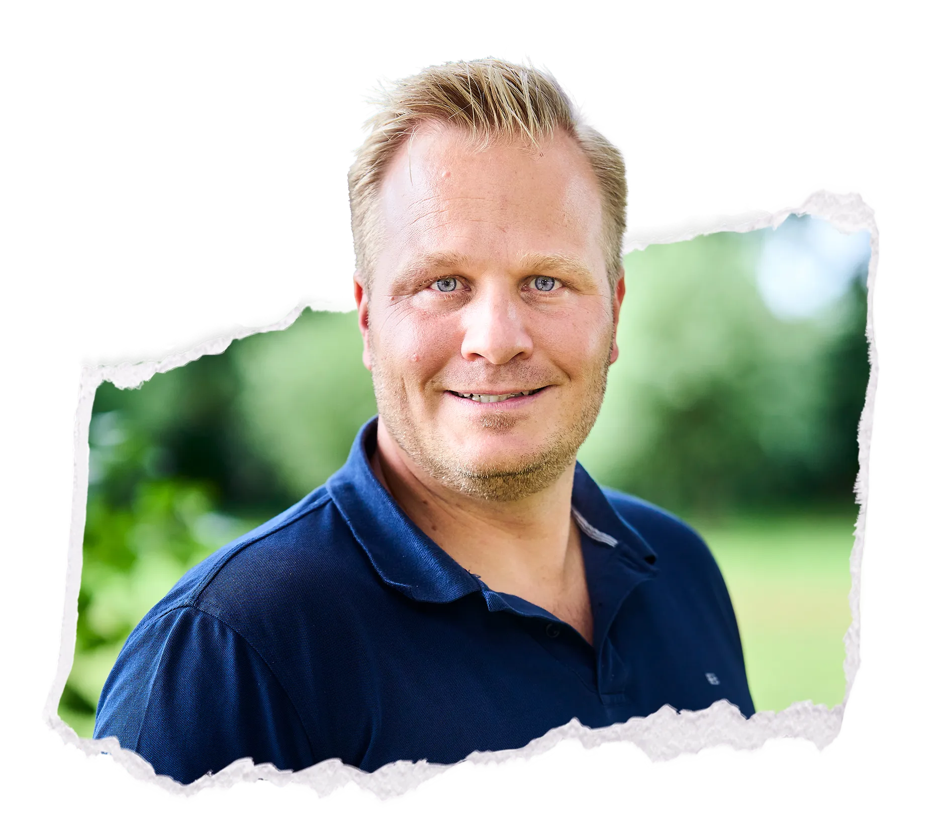 Porträt von Patrick Neumann im blauen Poloshirt vor unscharfem Grün, freundliches Lächeln im Freien